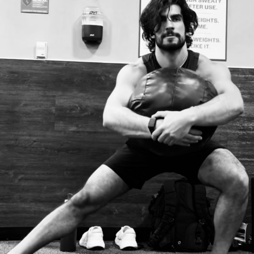 Coach Tyler seated in the gym